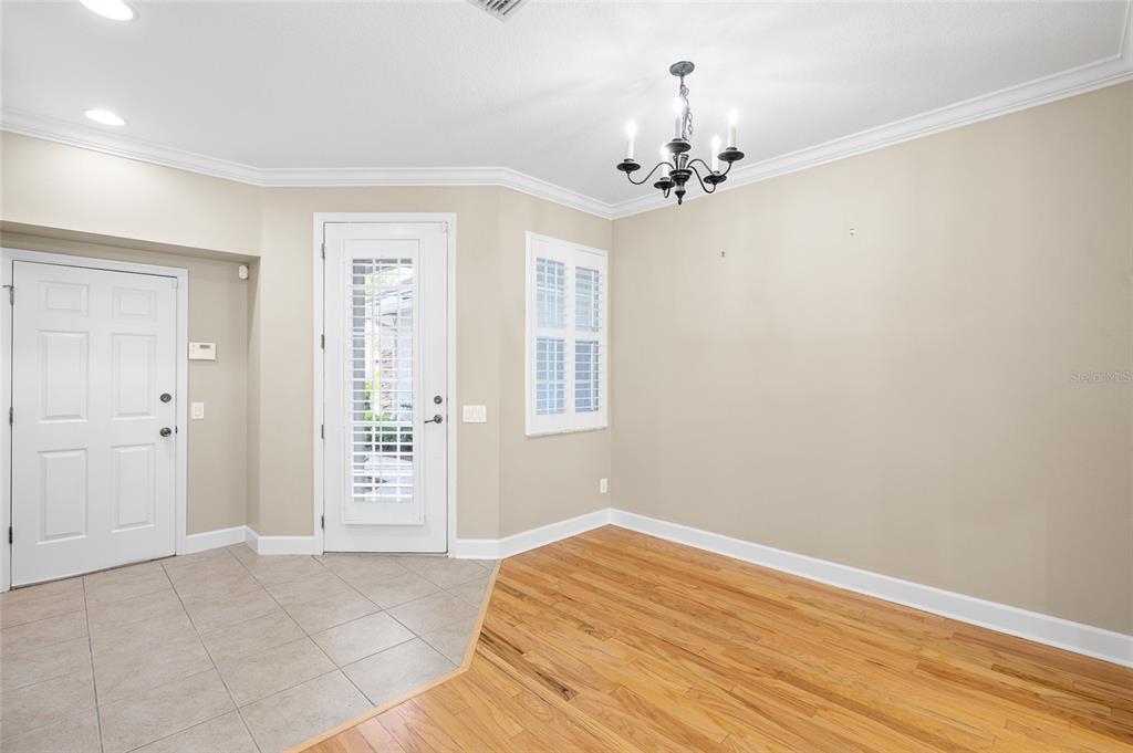 A dining area features hardwood floors, tile flooring near the doors, and a black chandelier — 14543 MIRABELLE VISTA CIRCLE, TAMPA, FL