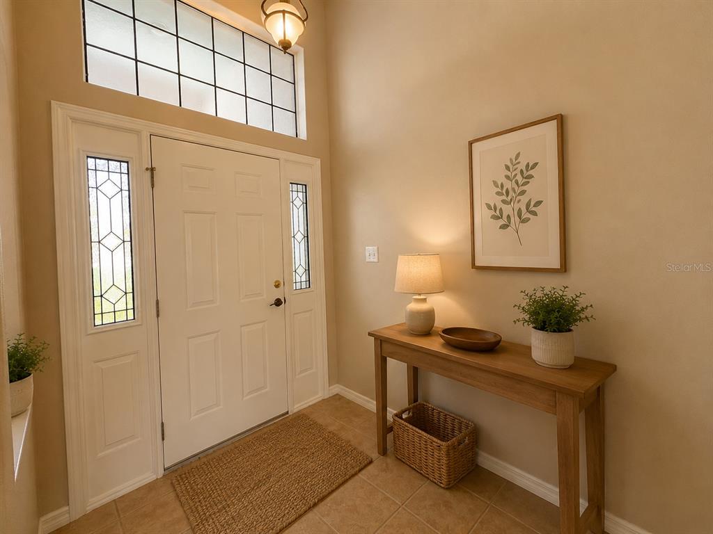 An entryway features a white front door with sidelights, a console table, and tile flooring — 5336 TIDEWATER STREET, LEESBURG, FL