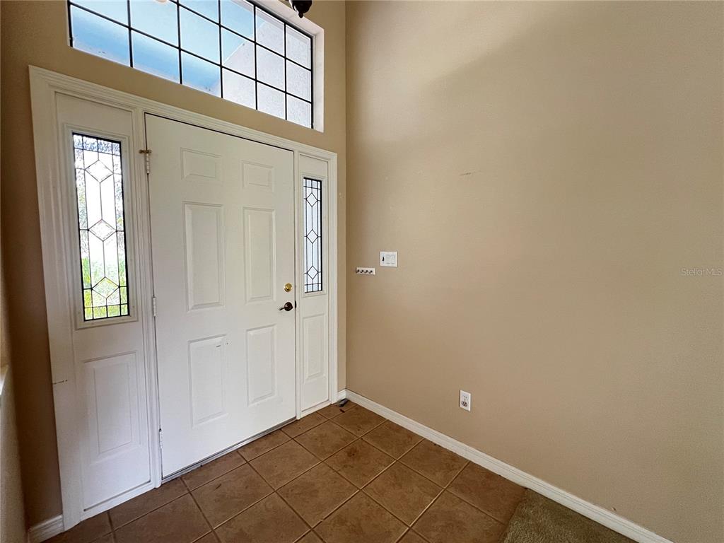 An entryway features a white front door with sidelights, a transom window, and tile flooring — 5336 TIDEWATER STREET, LEESBURG, FL