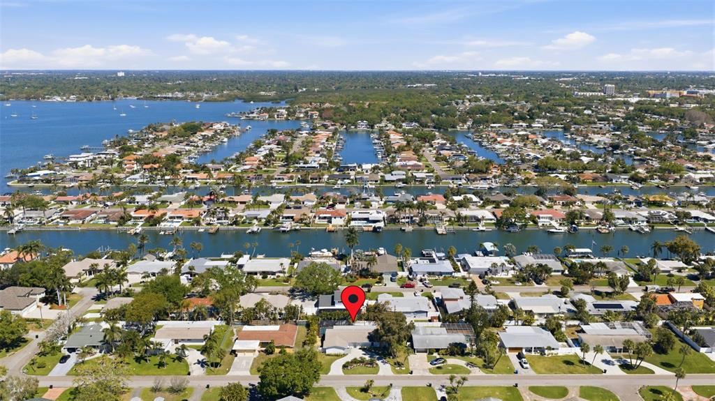 An aerial view shows a residential neighborhood with houses along a canal and bay — 4339 50TH AVENUE S, ST PETERSBURG, FL