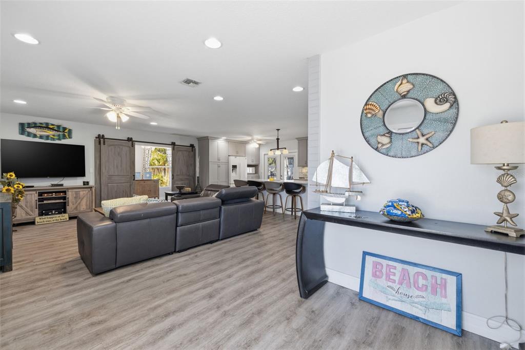A living room with gray flooring, a sectional sofa, and a console table with decor — 4339 50TH AVENUE S, ST PETERSBURG, FL