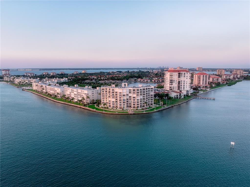 An aerial view shows multi-story waterfront apartment buildings on a peninsula surrounded by blue water — 6287 BAHIA DEL MAR CIRCLE UNIT 312, ST PETERSBURG, FL