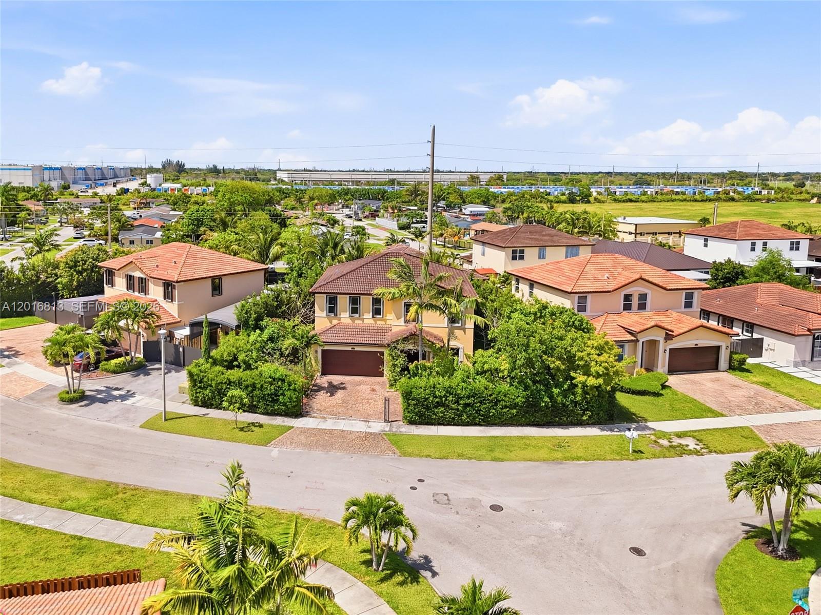 A two-story yellow house with a brown garage door and a paved driveway — 12921 SW 281st St, Homestead FL 33033, HOMESTEAD, FL