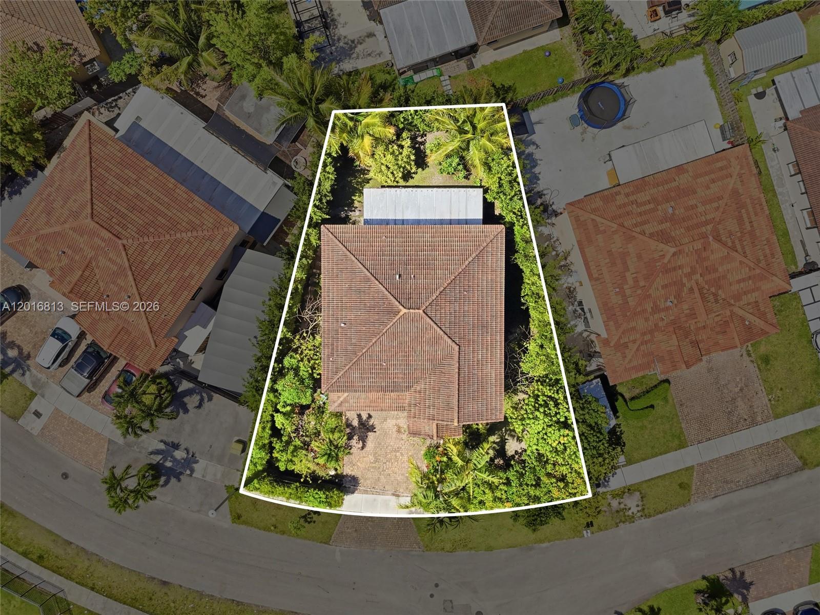 An open-concept living and dining area features tile flooring, brown leather furniture, and neutral walls — 12921 SW 281st St, Homestead FL 33033, HOMESTEAD, FL
