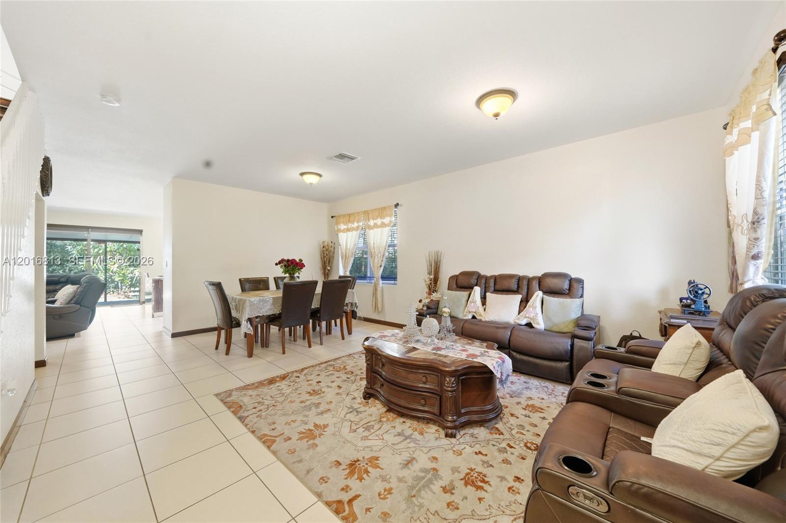 A modern kitchen features wood-grain cabinets, granite countertops, and stainless steel appliances — 12921 SW 281st St, Homestead FL 33033, HOMESTEAD, FL