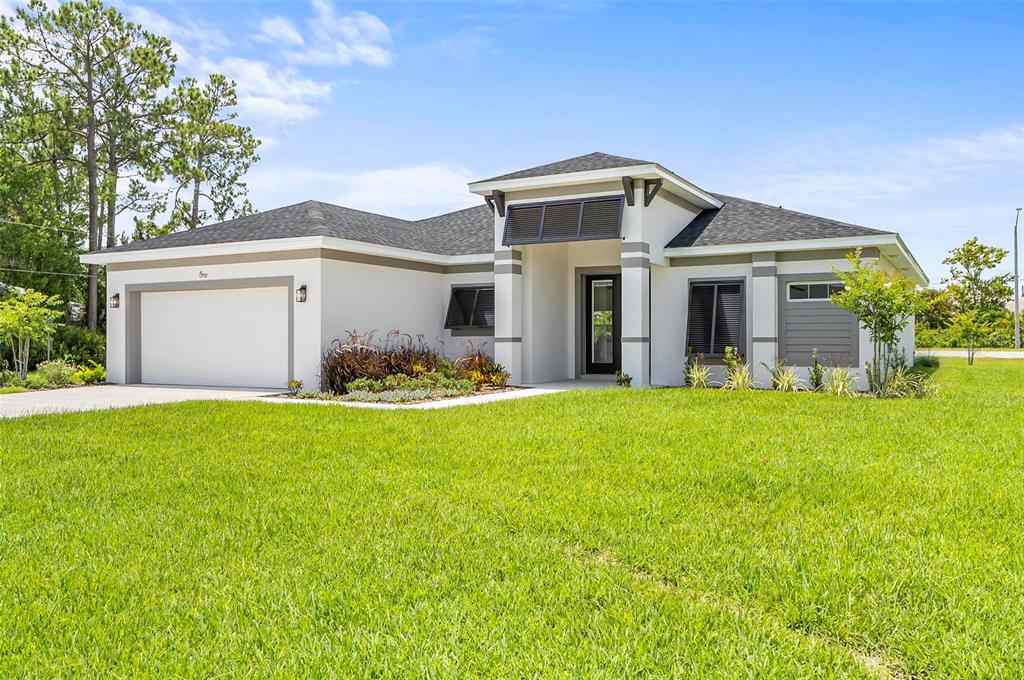 A single-story house with a white exterior, a two-car garage, and a dark shingled roof — 1 CLEMENTON LANE, PALM COAST, FL