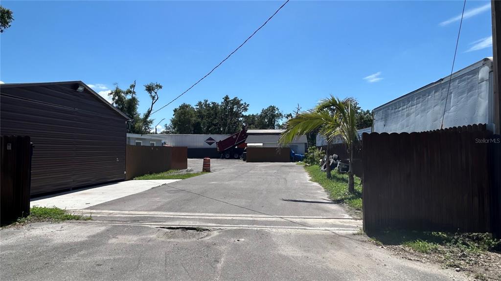 An outdoor view of a paved driveway between two buildings with a wooden fence — 2001 S 51ST STREET, TAMPA, FL