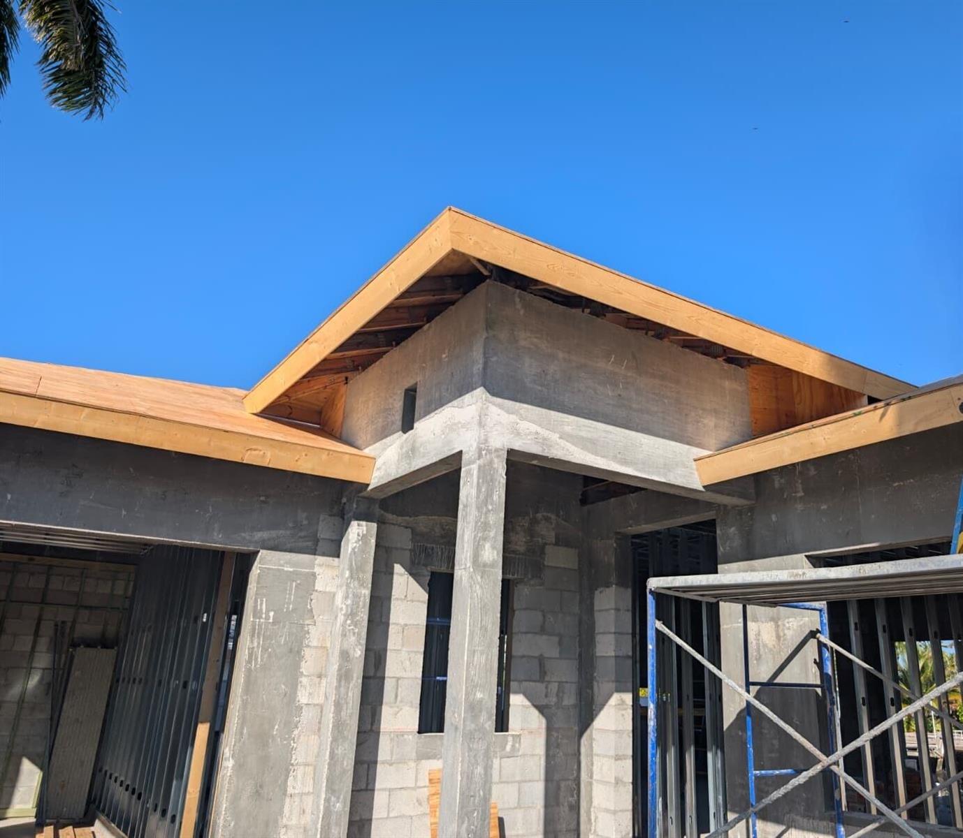 An exterior view of a concrete block house under construction with exposed wooden roof framing — 610 SE 5th Avenue, Pompano Beach FL 33060, POMPANO BEACH, FL