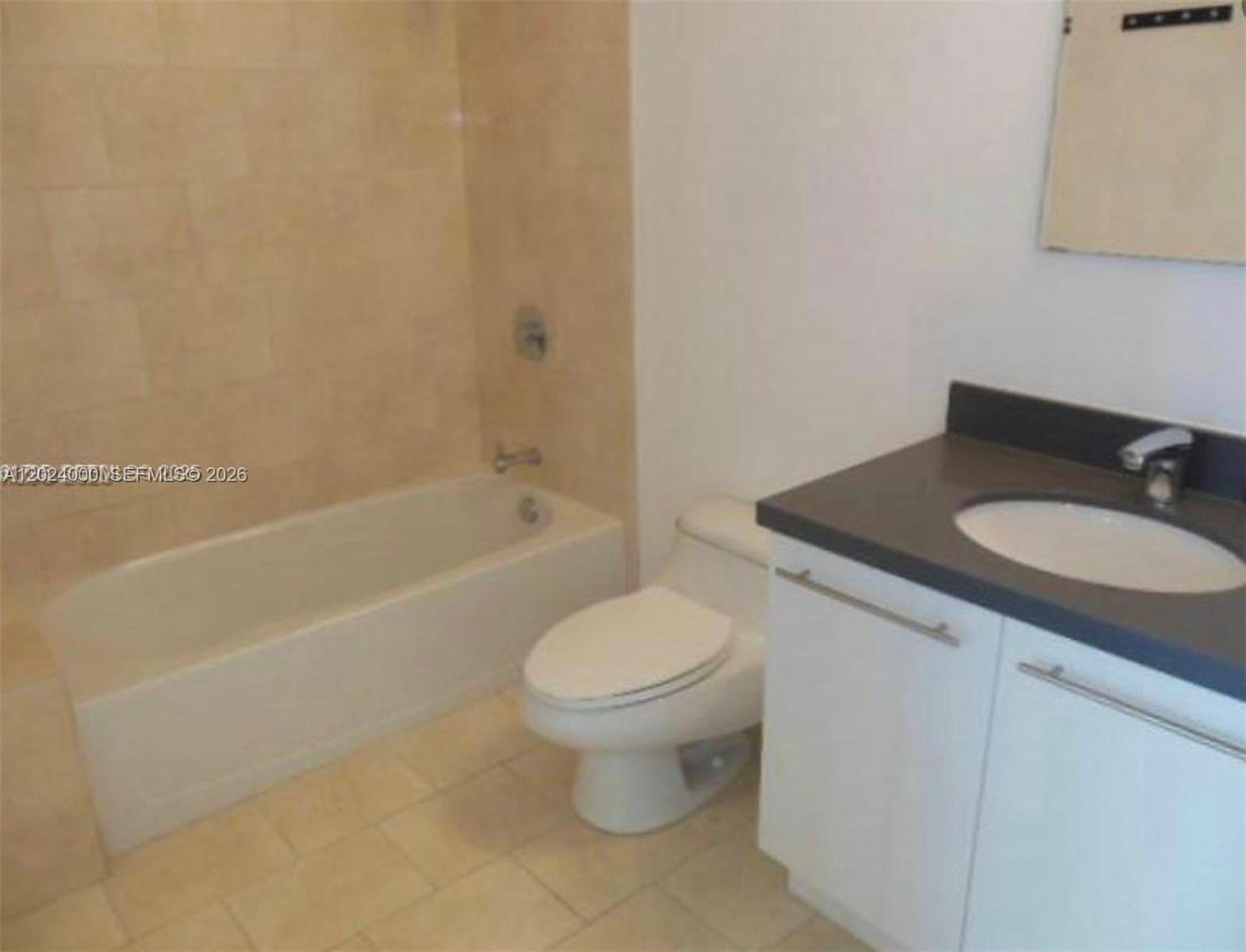 A bathroom features a bathtub with tiled walls, a white toilet, and a vanity — 90 SW 3rd St # 1811, Miami FL 33130, MIAMI, FL