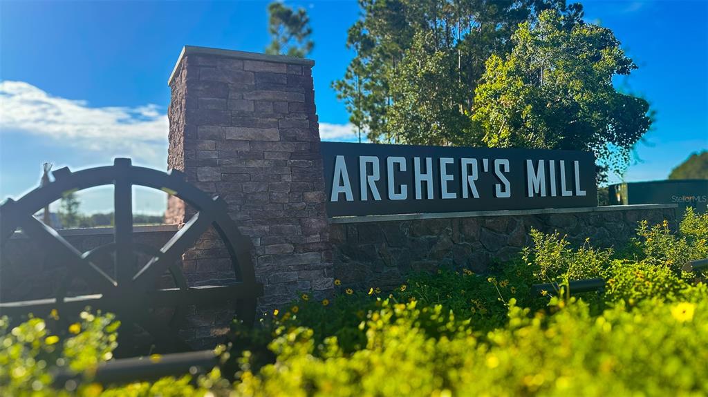 A stone monument sign for Archer's Mill features a water wheel and landscaping — 3024 KINGSMAN TRAIL, ORMOND BEACH, FL