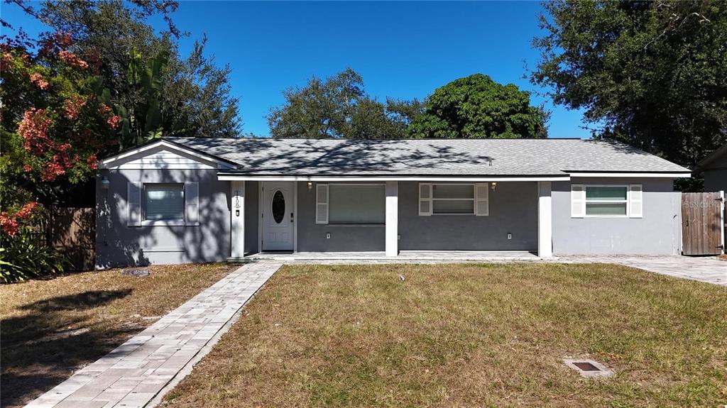 A single-story gray house with a paved walkway and a front porch under a roof — 1408 ROGERS STREET, CLEARWATER, FL