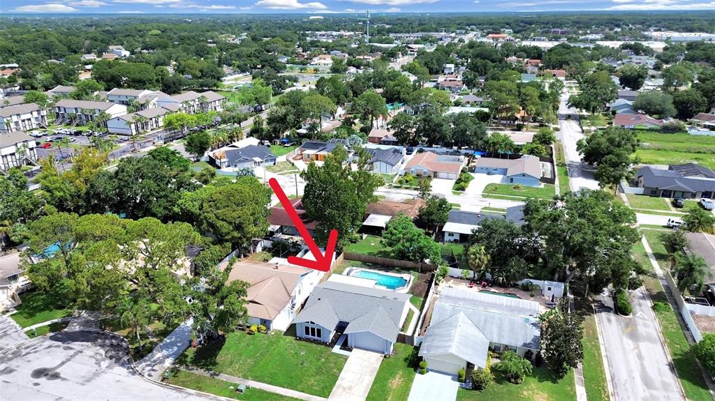 An aerial view shows a residential house with a swimming pool and a red arrow — 7513 MAYFAIR COURT, TAMPA, FL