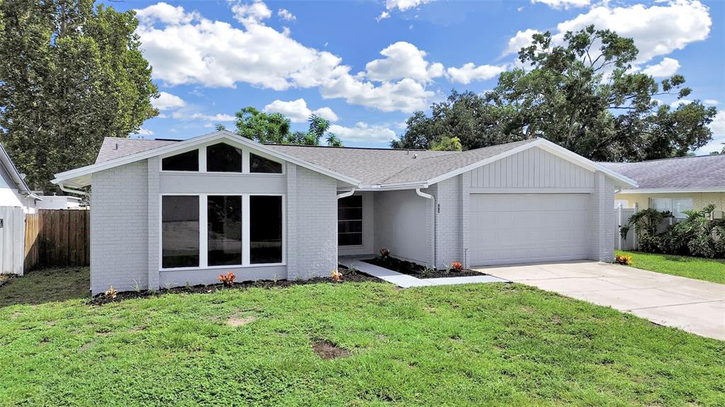A single-story house with a painted brick exterior, a two-car garage, and a large window — 7513 MAYFAIR COURT, TAMPA, FL