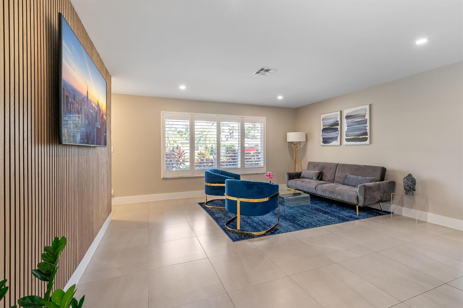 A living room features a slatted wood accent wall, blue velvet chairs, and a gray sofa — 300 SE 8th Court, Pompano Beach FL 33060, POMPANO BEACH, FL
