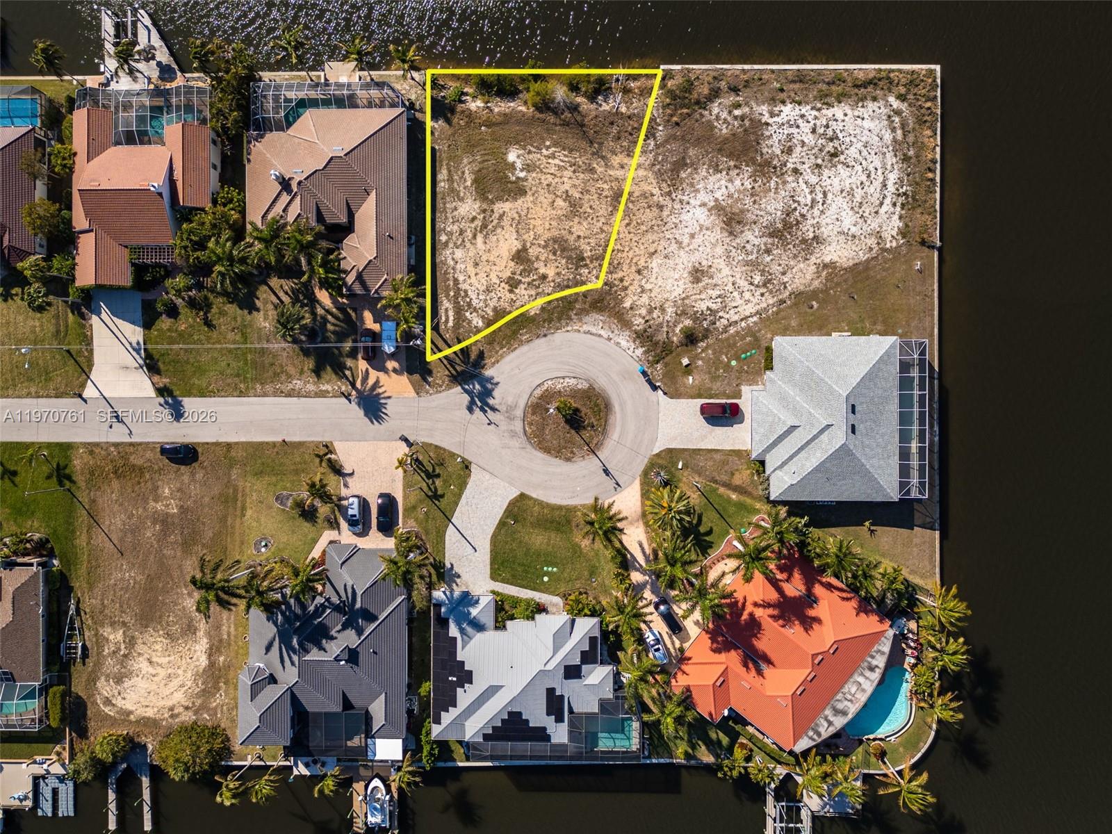 This aerial view shows a vacant waterfront lot located on a residential cul-de-sac — 2826 NW 43rd, Cape Coral FL 33993, CAPE CORAL, FL