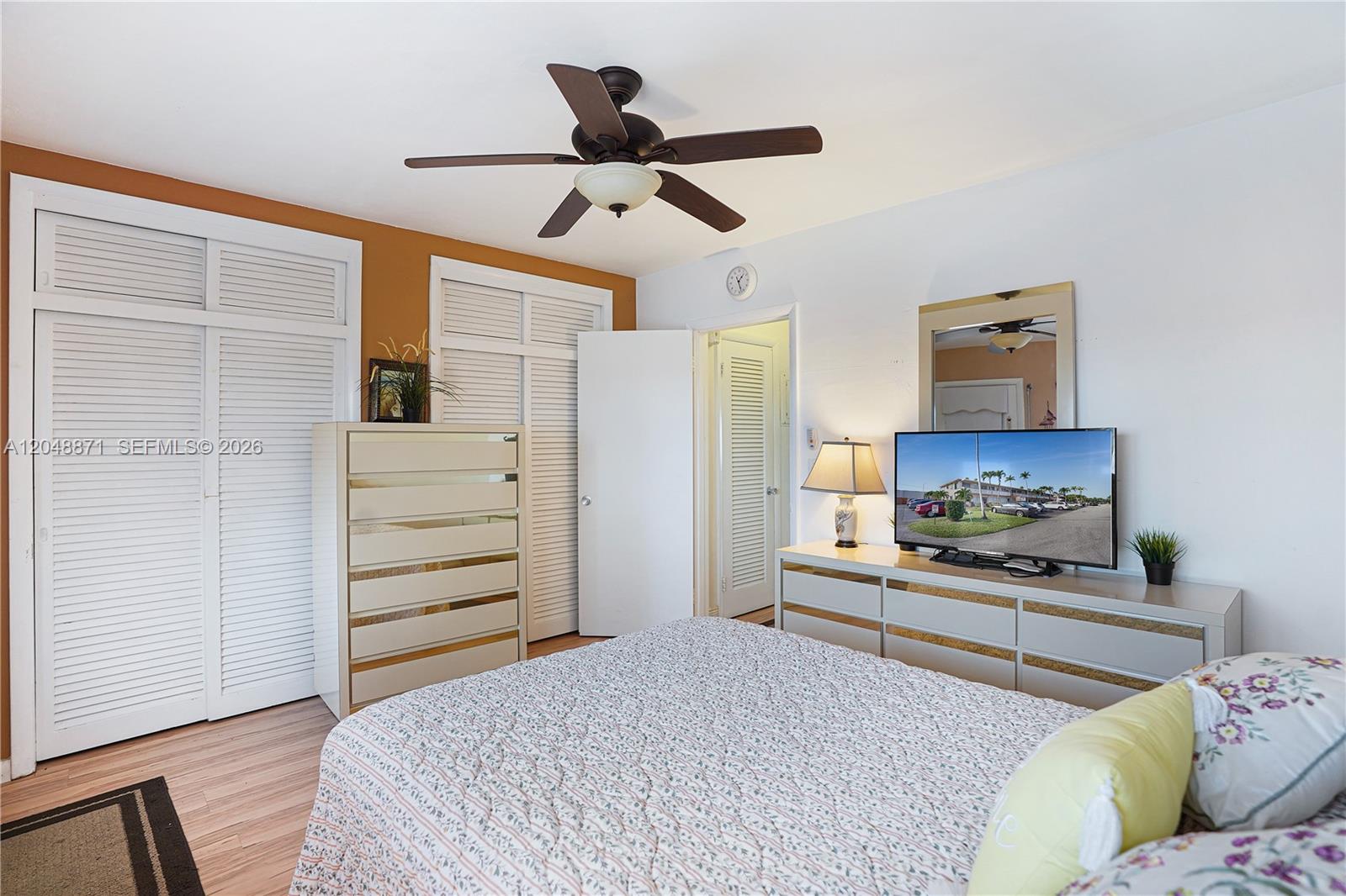 A bedroom features a ceiling fan, white louvered closet doors, and two matching mirrored dressers — 820 SW 11th Ave # 18B, Hallandale Beach FL 33009, HALLANDALE BEACH, FL