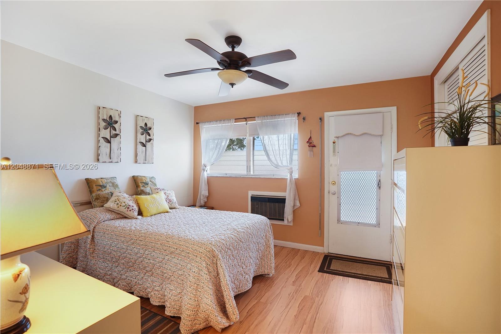 A bedroom features a bed, ceiling fan, window with curtains, and a door to outside — 820 SW 11th Ave # 18B, Hallandale Beach FL 33009, HALLANDALE BEACH, FL