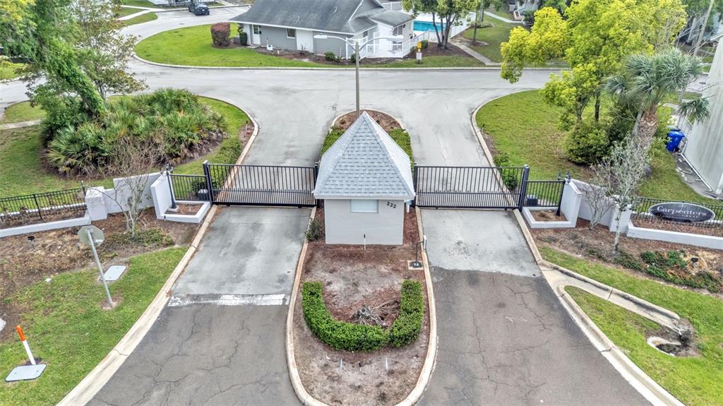 An aerial view shows a gated entrance with a guardhouse and two paved driveways — 222 CARPENTERS WAY UNIT 62, LAKELAND, FL