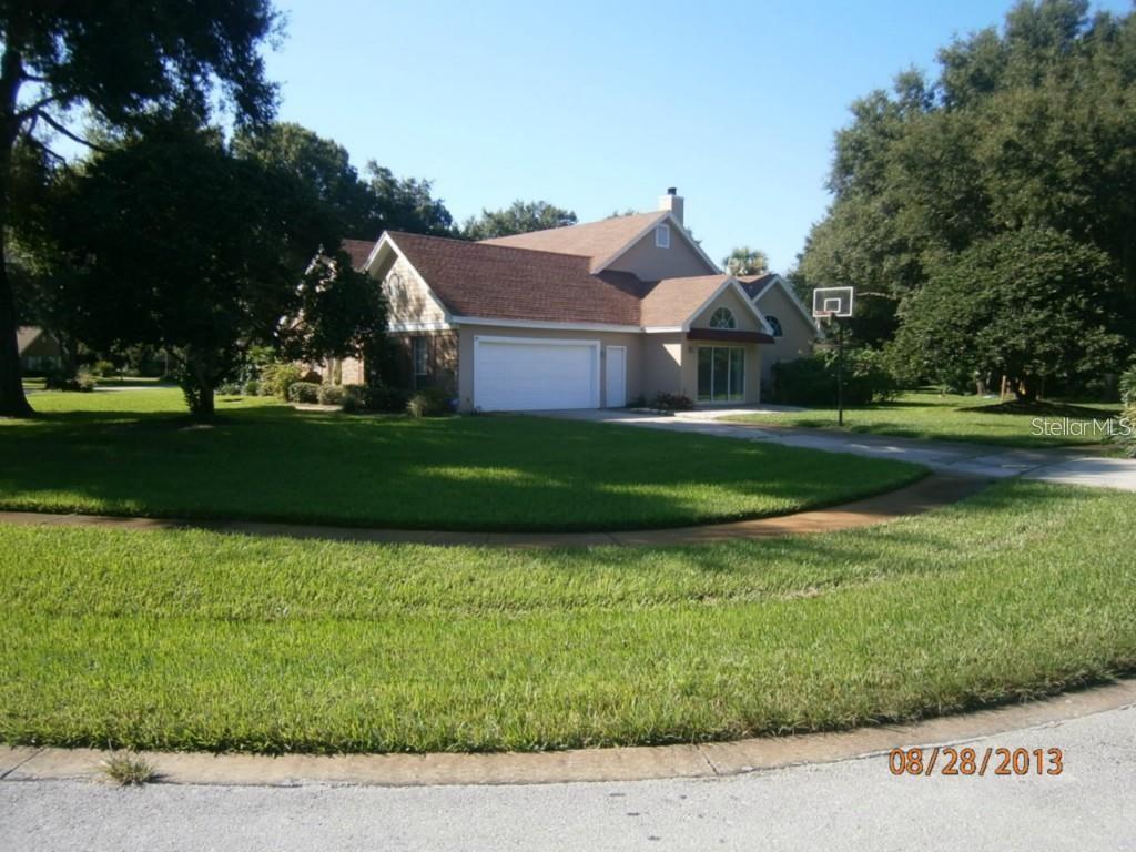 A tan house with a brown roof and a two-car garage sits on a lawn — 2630 STANTON HALL COURT, WINDERMERE, FL