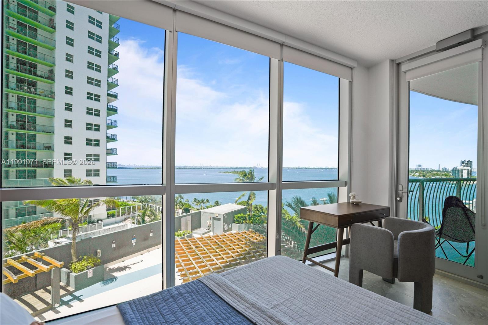 A bedroom features floor-to-ceiling windows with a view of the ocean and a balcony — 1750 N Bayshore Dr # 1401, Miami FL 33132, MIAMI, FL