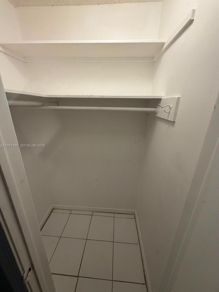 A closet with white walls, tiled flooring, a hanging rod, and two shelves — 314 S J St # 4, Lake Worth FL 33460, LAKE WORTH, FL