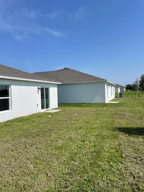 The exterior view shows the side and back of a white house with a sliding door — 2930 PENNACHIO DRIVE, LAKE WALES, FL