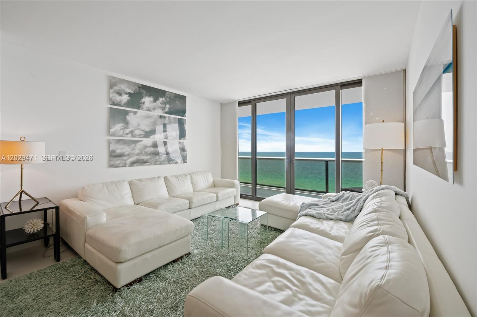 A living room features two white leather sofas, a glass coffee table, and ocean views — 9455 Collins Ave # 1208, Surfside FL 33154, SURFSIDE, FL