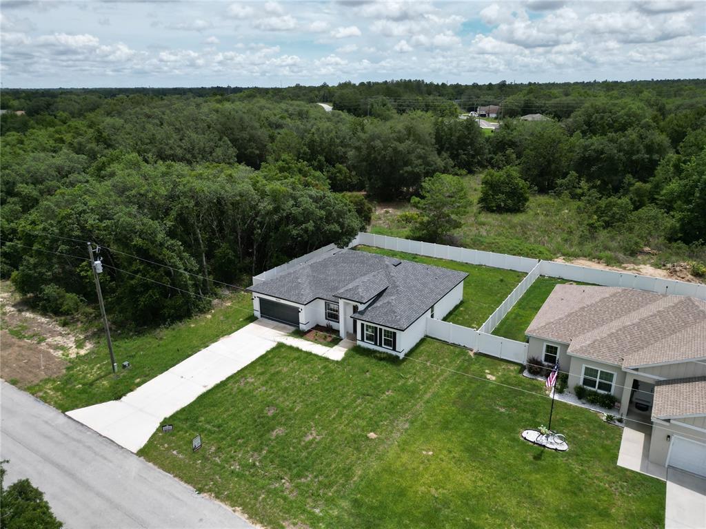 An aerial view shows a white single-story house with a gray roof and fenced yard — 15333 SW 59TH AVENUE RD, OCALA, FL