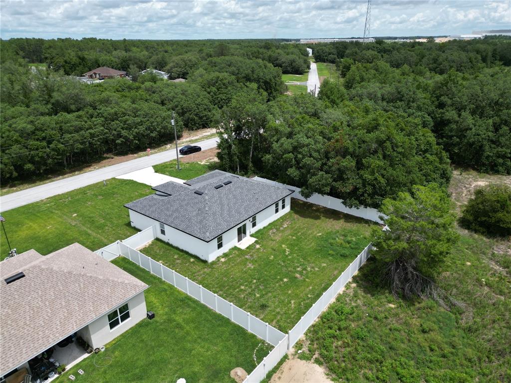 An aerial view shows a white house with a gray roof and a fenced yard — 15333 SW 59TH AVENUE RD, OCALA, FL