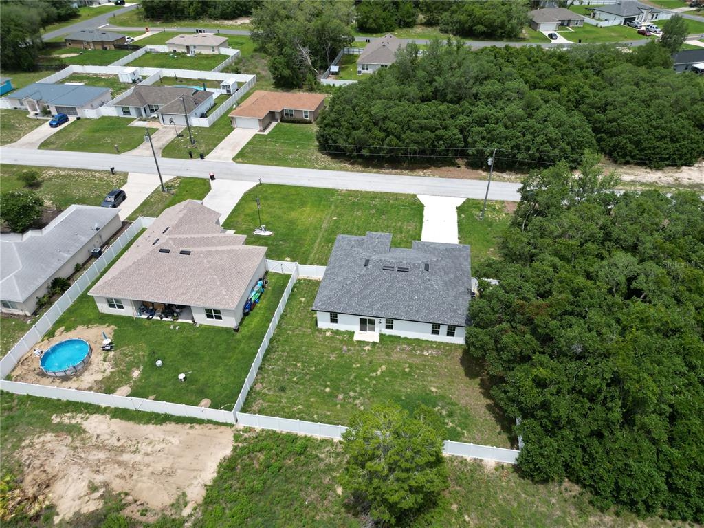 An aerial view shows two suburban houses with fenced backyards and surrounding trees — 15333 SW 59TH AVENUE RD, OCALA, FL