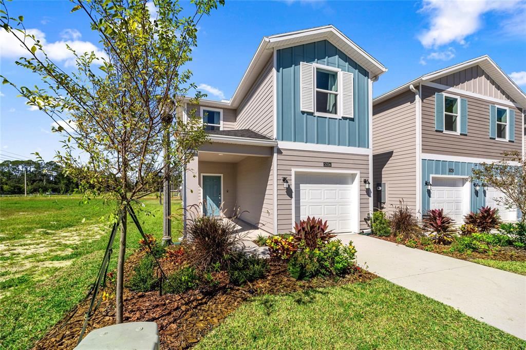 A two-story house with a blue vertical-siding accent, a single-car garage, and a front porch — 5422 NW 22ND DRIVE, GAINESVILLE, FL
