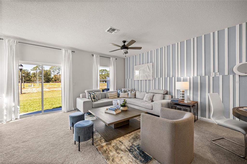 A living room features a sectional sofa, a coffee table, and a striped accent wall — 5422 NW 22ND DRIVE, GAINESVILLE, FL