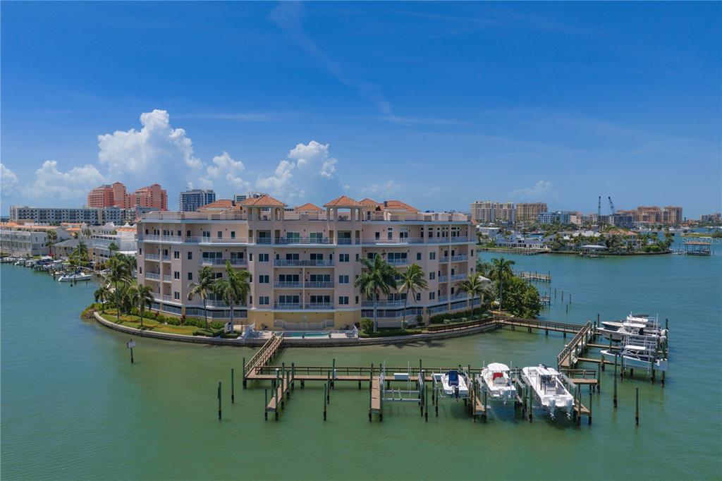 An aerial view of a waterfront residential complex with boat docks and a swimming pool — 205 BRIGHTWATER DRIVE UNIT 205, CLEARWATER BEACH, FL