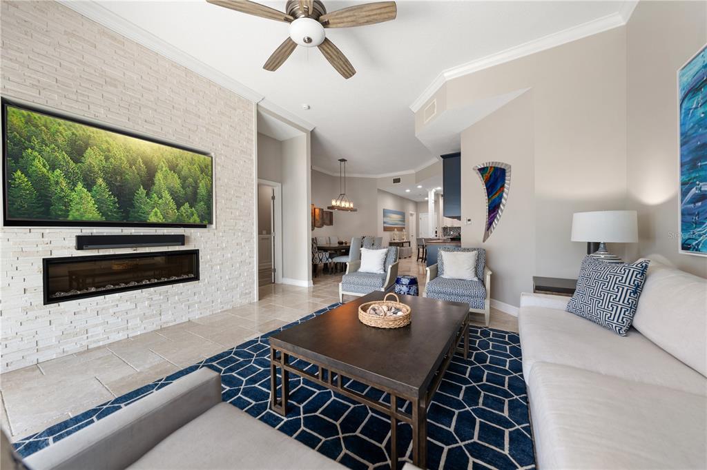 A foyer features a console table with two lanterns, patterned ottomans, and a beach-themed wall canvas — 205 BRIGHTWATER DRIVE UNIT 205, CLEARWATER BEACH, FL