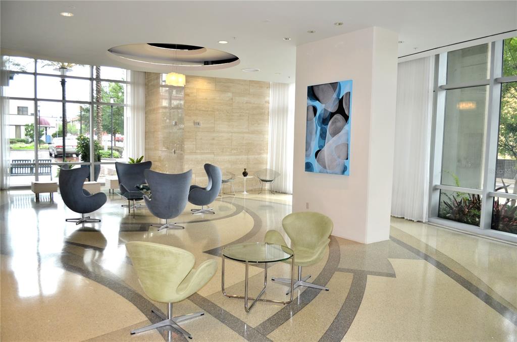 A modern lobby features a polished terrazzo floor, contemporary chairs, and large floor-to-ceiling windows — 150 E ROBINSON STREET UNIT 2012, ORLANDO, FL