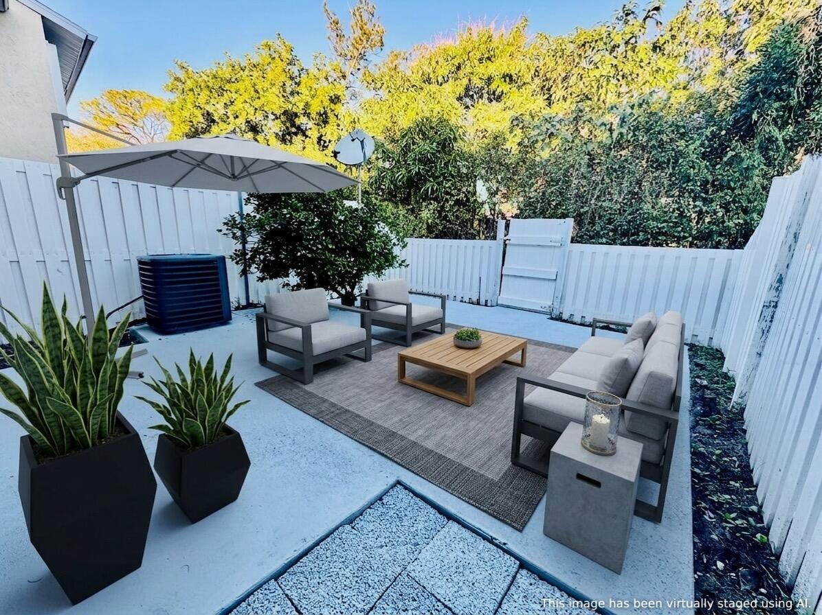 A sunroom with artificial grass flooring features a screen door leading to a fenced patio — 222 Foxtail Drive, FL 33415, FL