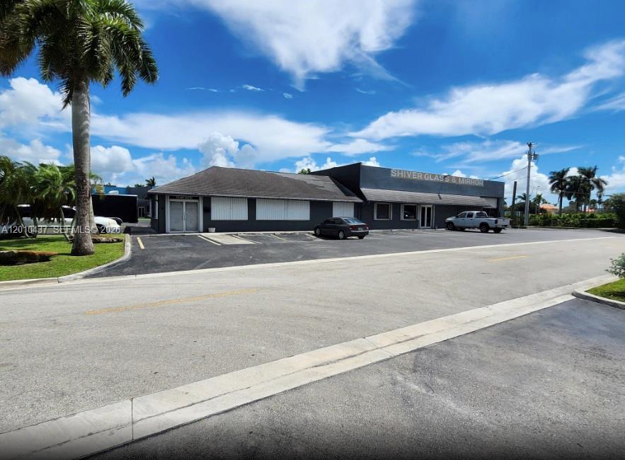 A commercial building with a dark exterior and a parking lot under a blue sky — 10 NE 3rd St, Florida City FL 33034, FLORIDA CITY, FL