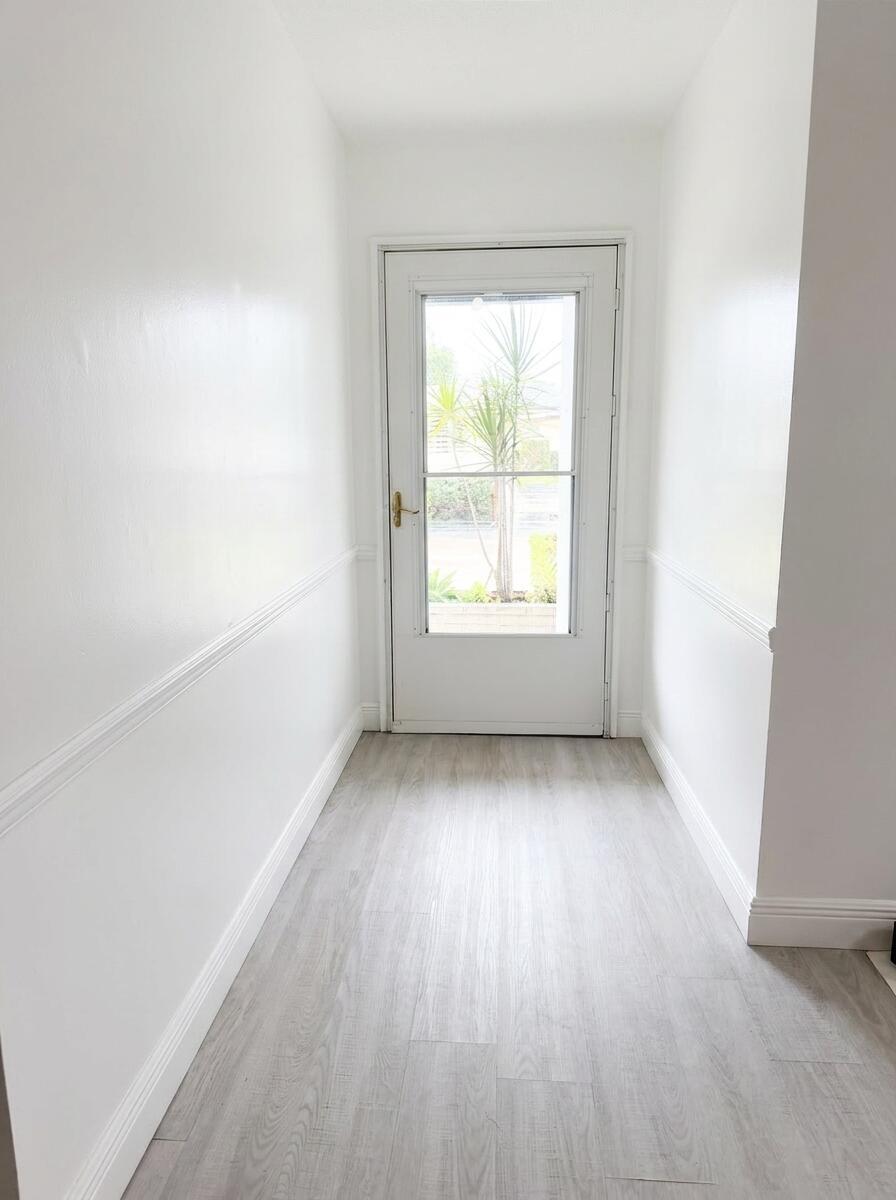 A narrow entryway with white walls, chair rail molding, and light-colored wood-look flooring — 2898 Ashley Dr Drive E # C, West Palm Beach FL 33415, WEST PALM BEACH, FL