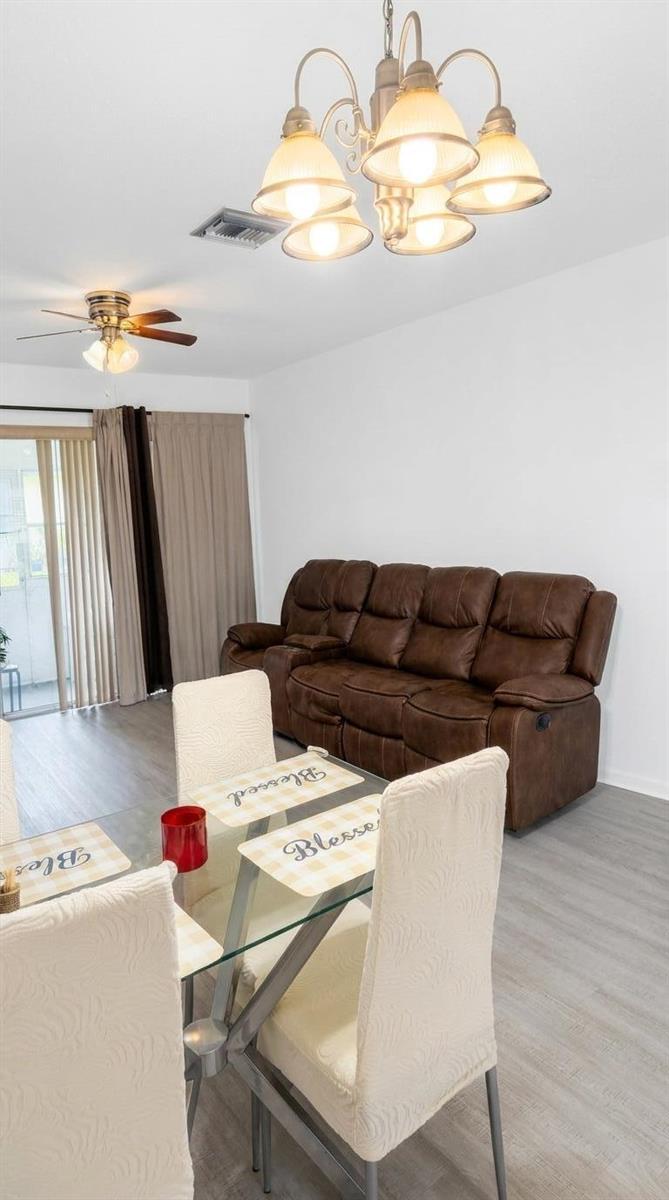 A living and dining area features a brown reclining sofa, glass table, and ceiling lights — 2898 Ashley Dr Drive E # C, West Palm Beach FL 33415, WEST PALM BEACH, FL