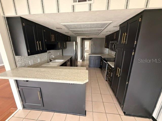 A kitchen features black cabinets, a light-colored countertop, and a tiled floor — 7 CLEE CT, PALM COAST, FL