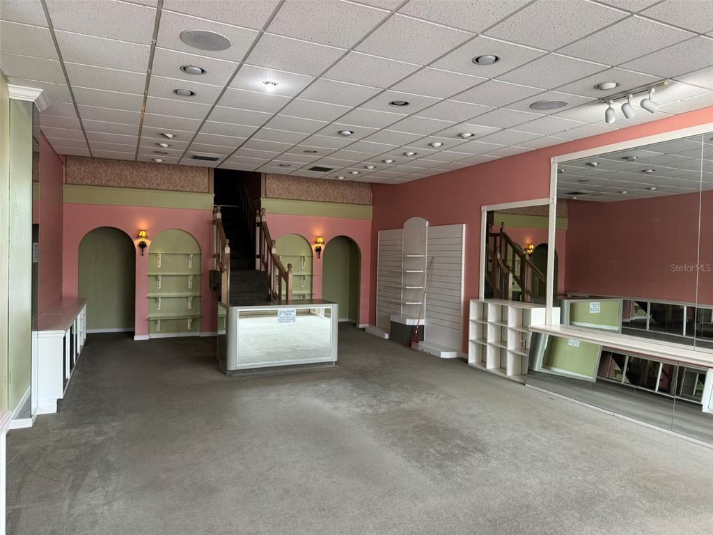 A commercial retail space features pink walls, arched shelving, a central counter, and mirrored walls — 3411 SW 34TH STREET, GAINESVILLE, FL
