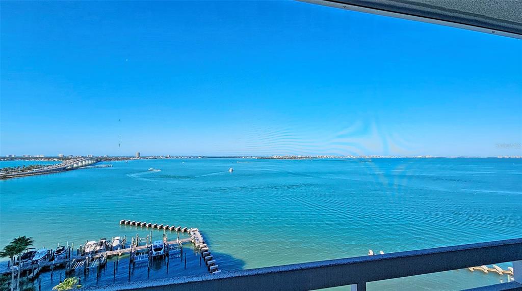 A high-angle view shows a blue bay with a boat dock and a distant bridge — 988 BLVD OF THE ARTS UNIT 1411, SARASOTA, FL