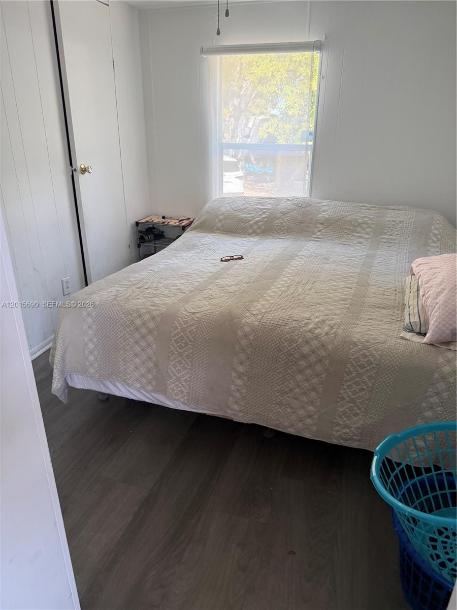 A bedroom features a bed with a textured quilt, a window, and wood-look flooring — 103650 Overseas Hwy, Key Largo FL 33037, KEY LARGO, FL