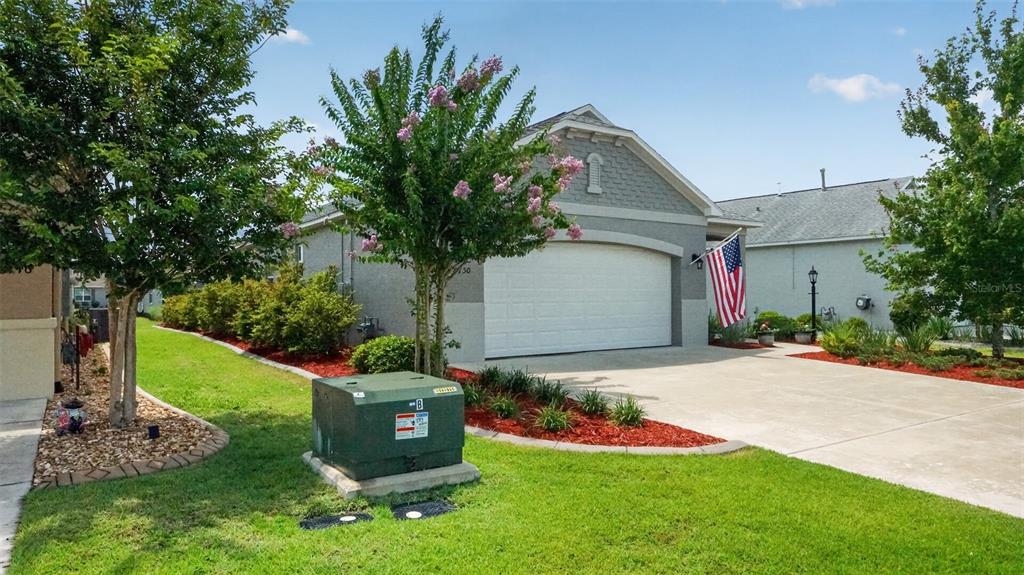 A single-story house with a two-car garage, a green utility box, and landscaping — 8750 SW 76TH STREET ROAD, OCALA, FL