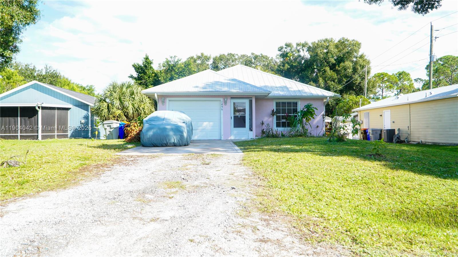 A single-story pink house with a white roof and a gravel driveway — 1496 SW 24th Ave SW, Vero Beach FL 32962, VERO BEACH, FL