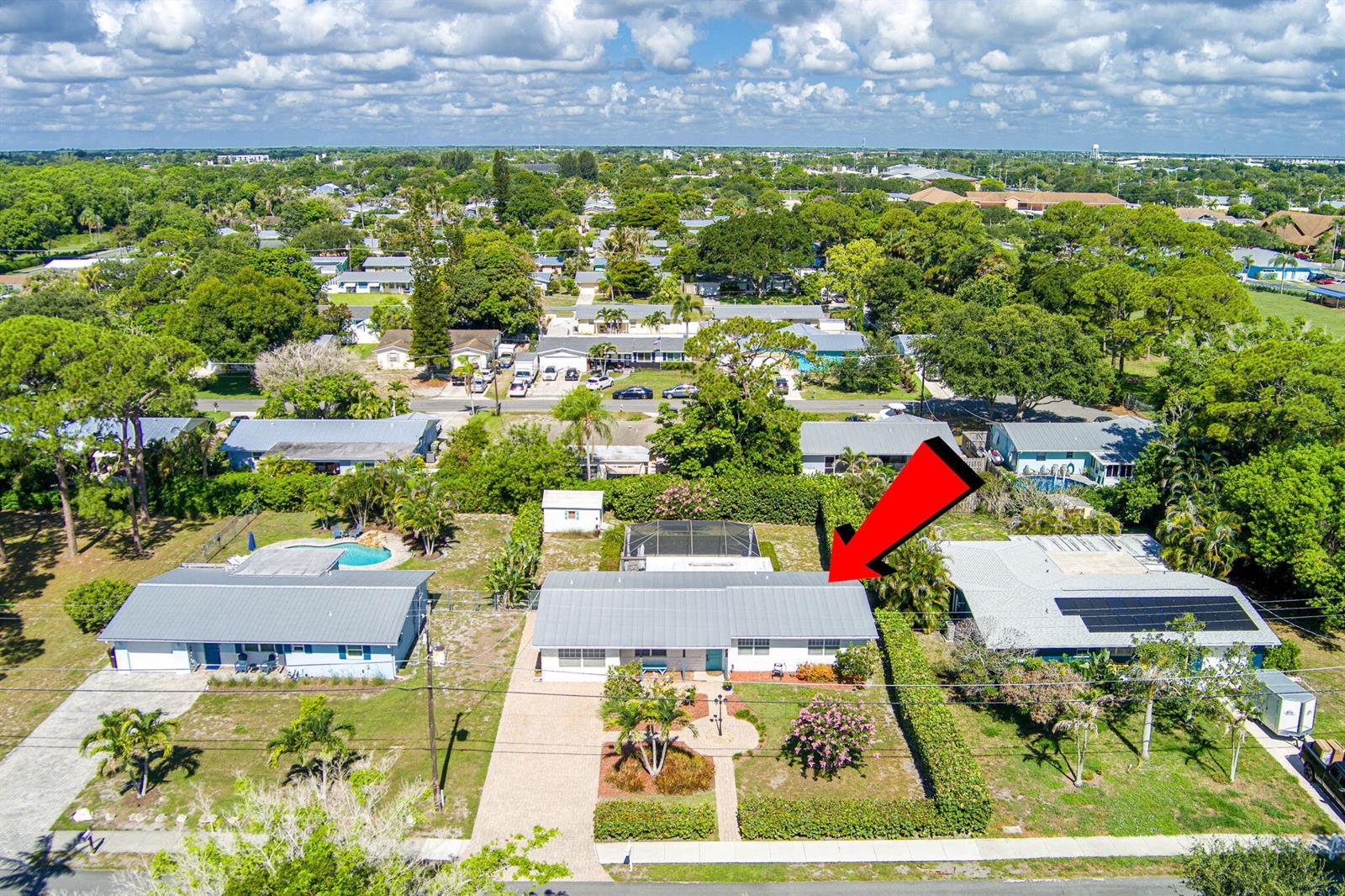 An aerial view shows a single-story house with a metal roof and a front yard — 1252 SE Madison Avenue, Stuart FL 34996, STUART, FL