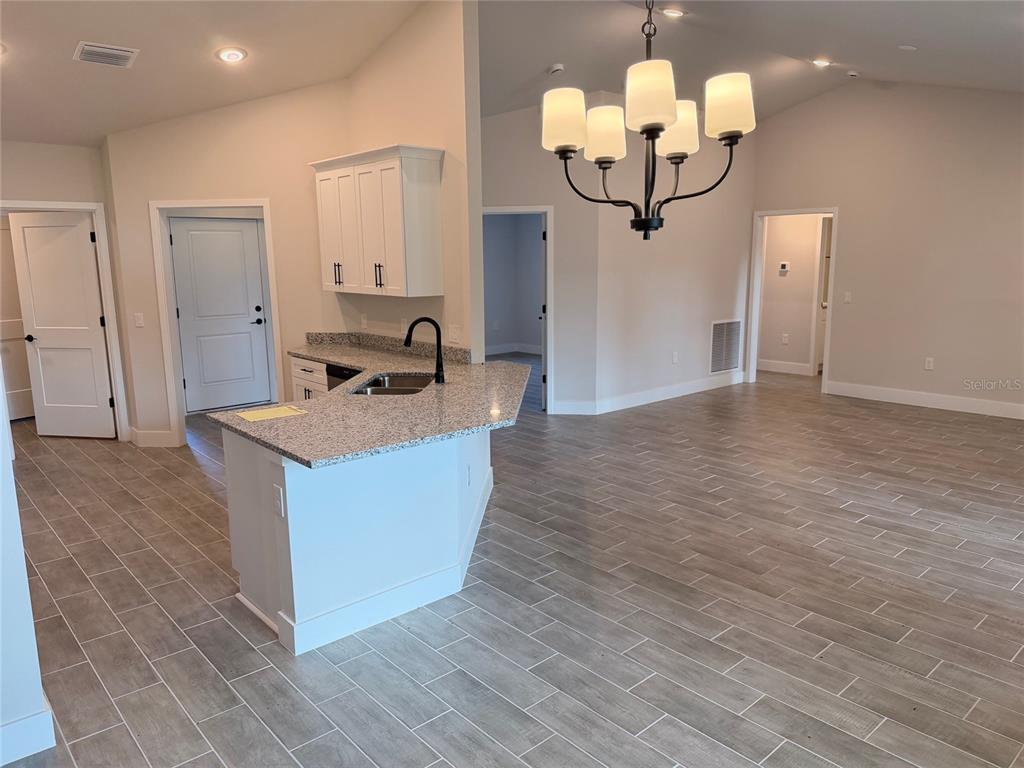 A kitchen with granite countertops and a breakfast bar overlooks an open living area — 17433 EDGEWATER DRIVE, PORT CHARLOTTE, FL