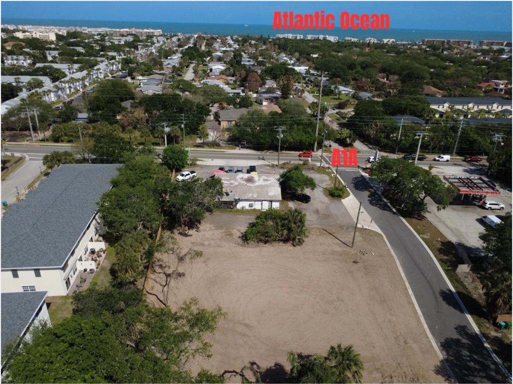 An aerial view shows a vacant lot near a road and the Atlantic Ocean — OAK LANE, CAPE CANAVERAL, FL