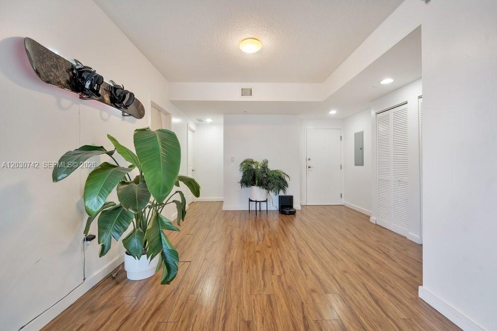 This interior view shows a room with wood-look flooring, white walls, and a snowboard display — 601 NE 23rd St # 1406, Miami FL 33137, MIAMI, FL