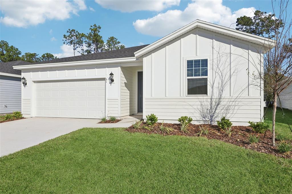 A white, single-story house with a two-car garage and a front-facing window — 51 WANDERING CREEK WAY, PALM COAST, FL